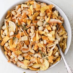 Mixed tropical trail mix in a large bowl with a spoon.
