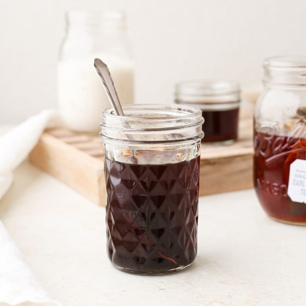 A jar of homemade earl grey simple syrup with a spoon.