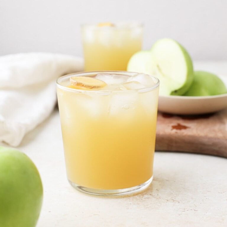 Green apple mocktails with lemon ginger simple syrup next to fresh green apples.