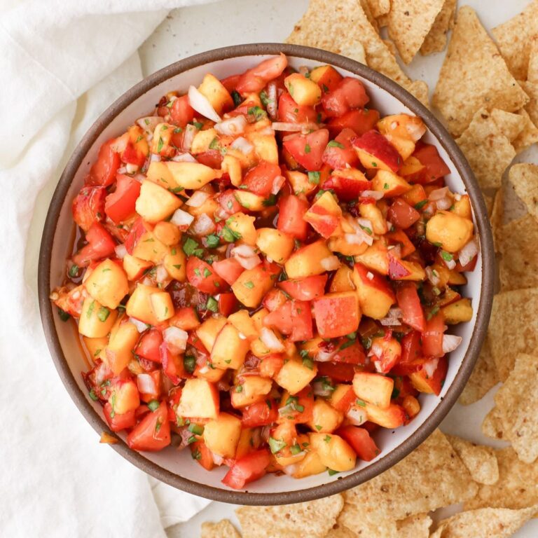 A bowl of homemade Trader Joe's smoky peach salsa served with tortilla chips.