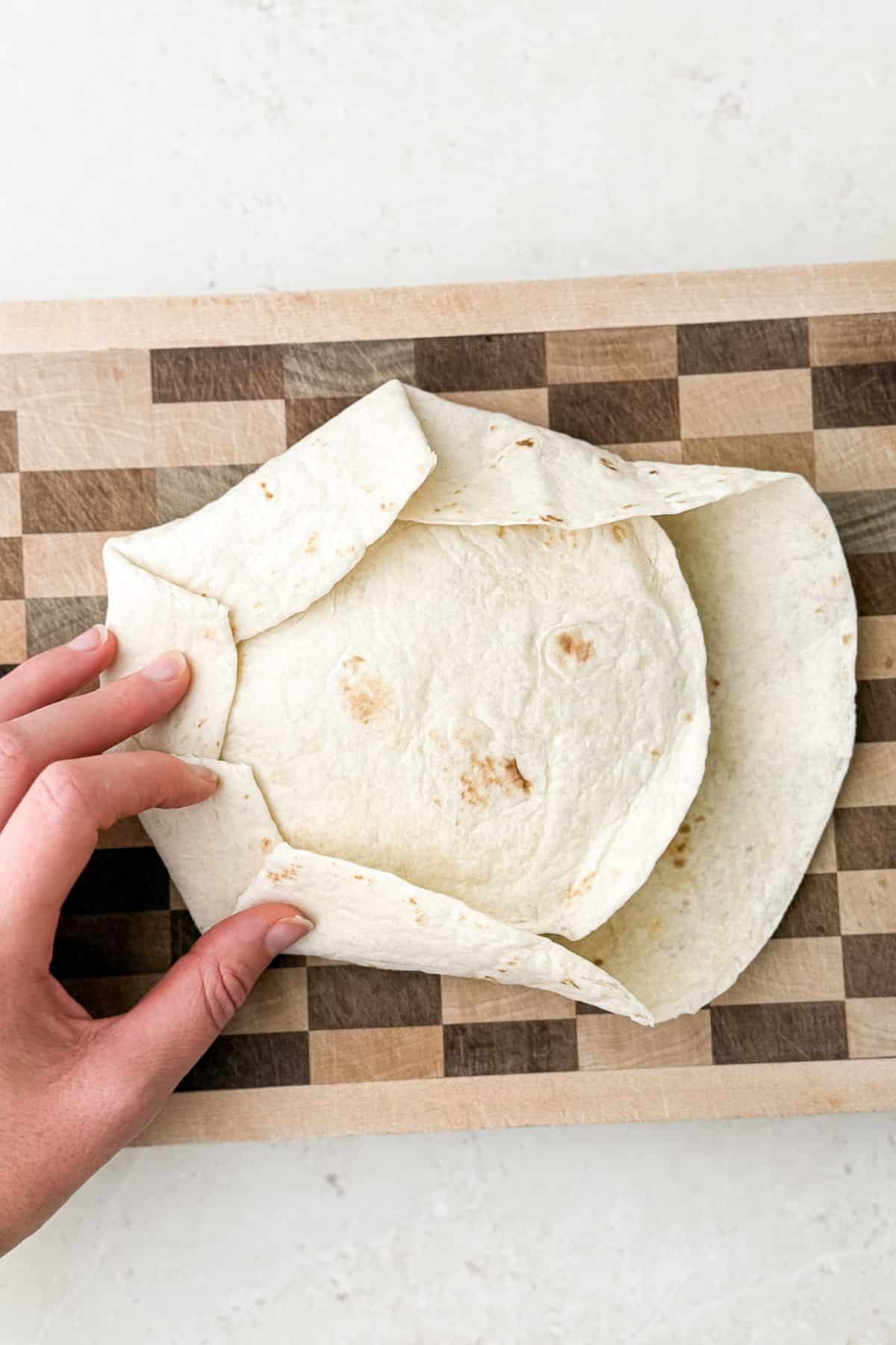 Making the pleats/folds for the crunchwrap supreme.