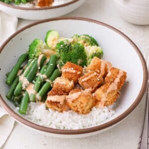Crispy tofu bowl with rice, blanched green beans and broccoli, and bang bang sauce.