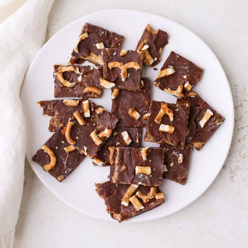 Date bark topped with crushed pretzels on a plate.