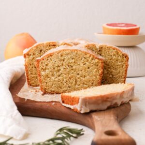Slices of a grapefruit cake loaf with rosemary and a fresh grapefruit glaze.
