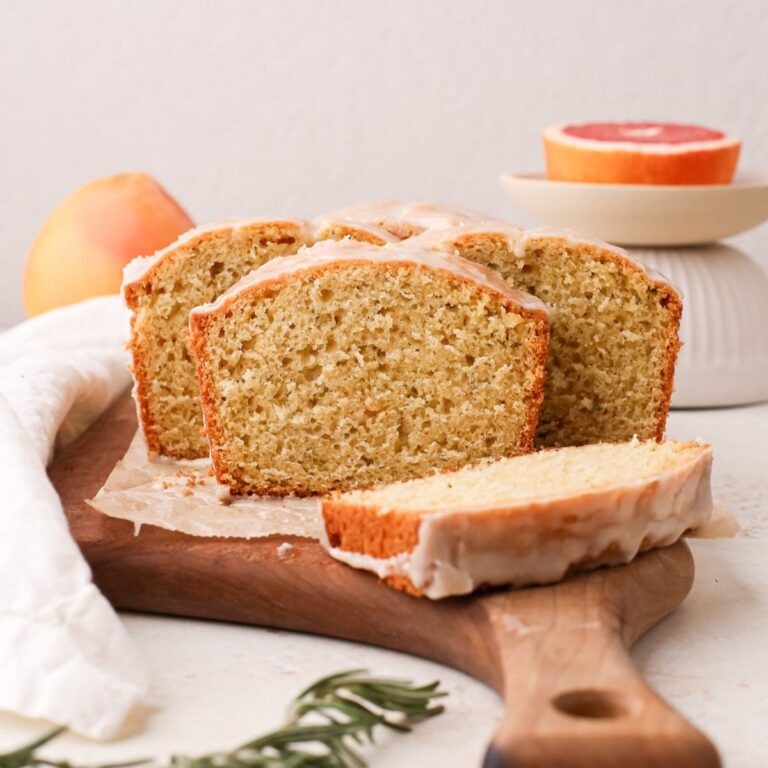 Slices of a grapefruit cake loaf with rosemary and a fresh grapefruit glaze.