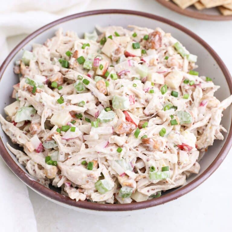 A bowl of honey mustard chicken salad with fresh chives.