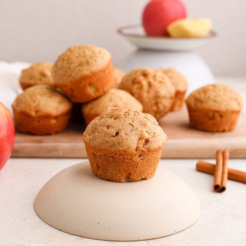 Apple cinnamon muffins on a plate and cutting board.