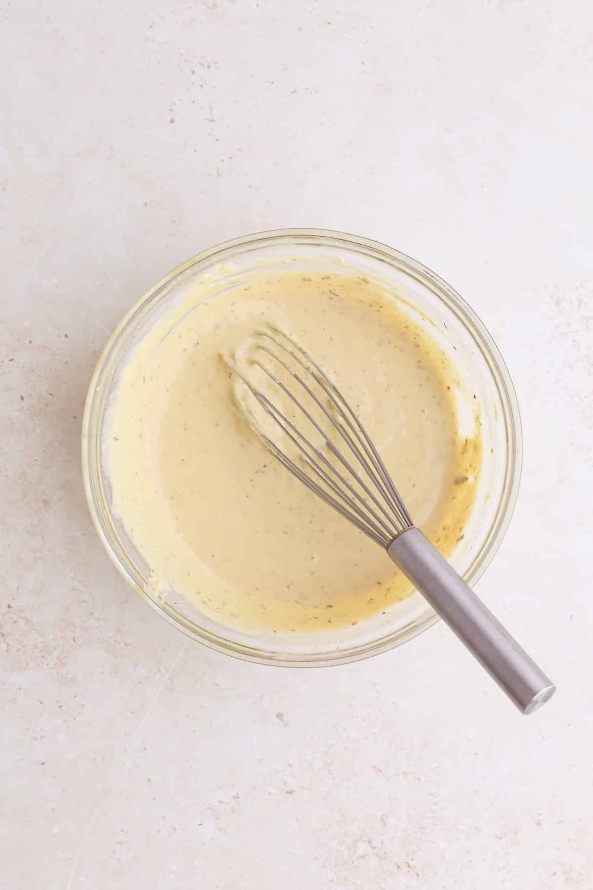A bowl of creamy, dairy free Italian dressing for marry me chicken salad.