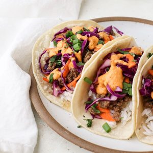 Korean beef bulgogi tacos are a plate topped with a colorful slaw and kimchi mayo.